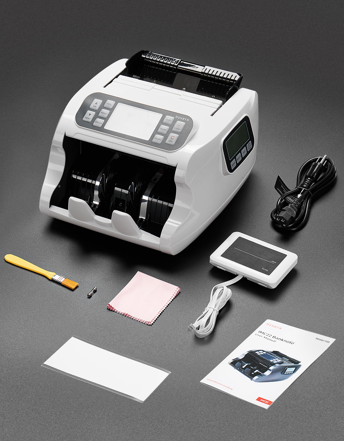 A white and black currency counter machine is shown with its accessories